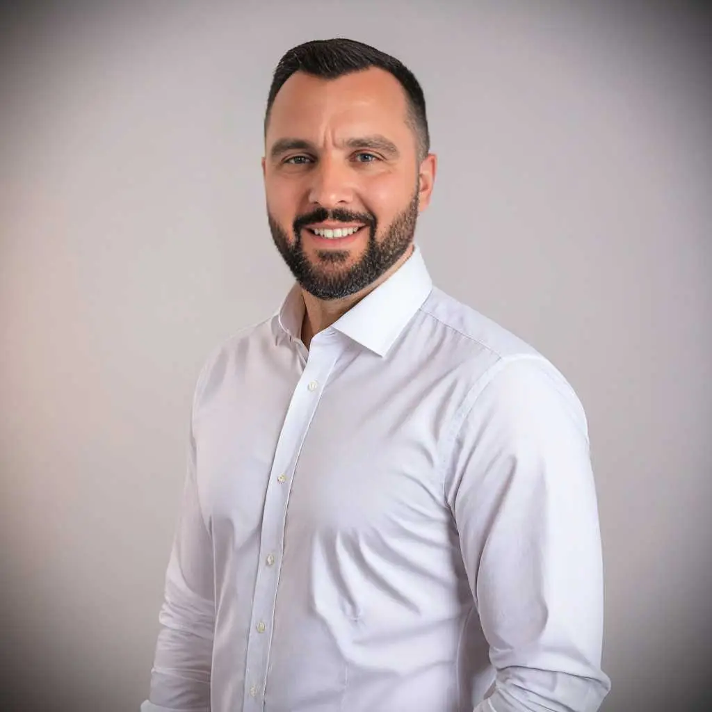 Professional agent with short dark hair and beard in white shirt, representing prime Ekosphere Ulcinj properties on immorenta.me.