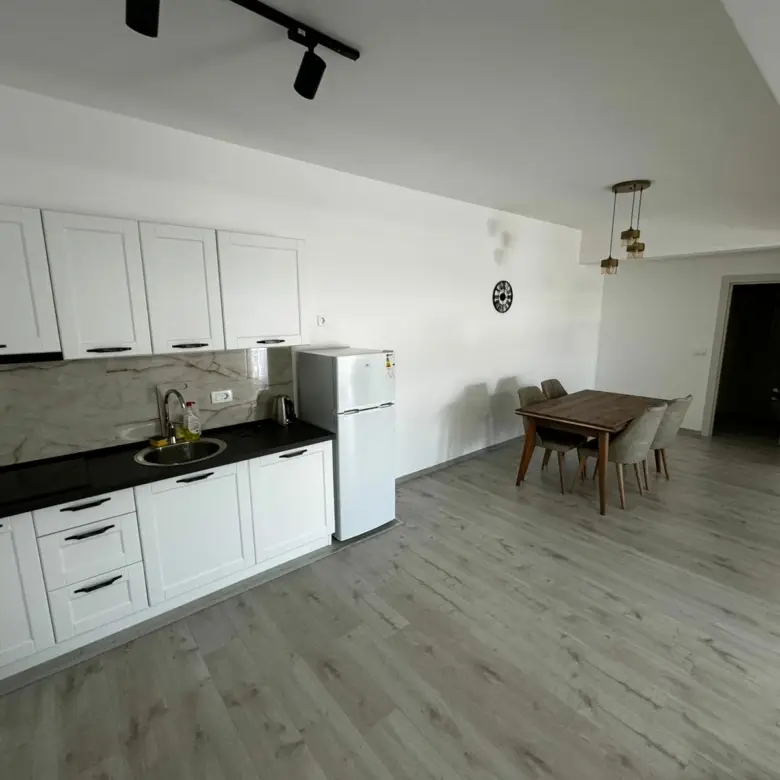 Stunning Ulcinj kitchen with sleek white cabinets, dining nook, and airy design&mdash;exclusive listing on immorenta.me by Ekosphere.