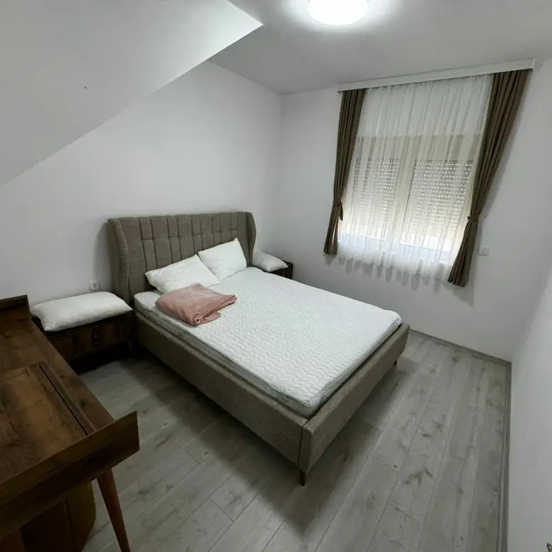 Bright, airy Ulcinj bedroom with double bed, nightstands, dresser, and window&mdash;prime real estate at immorenta.me by ekosphere doo.
