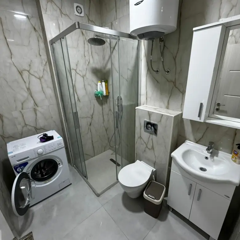 Premium modern bathroom in Ulcinj property: marble walls, glass shower, top fixtures; exclusive at immorenta.me by ekosphere doo.