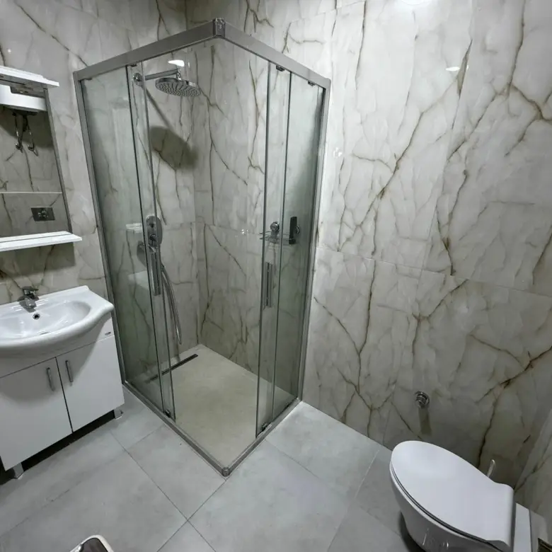 Luxurious Ulcinj property: modern bathroom with marble accents, glass shower, elegant finishes. Invest via immorenta.me Ekosphere.