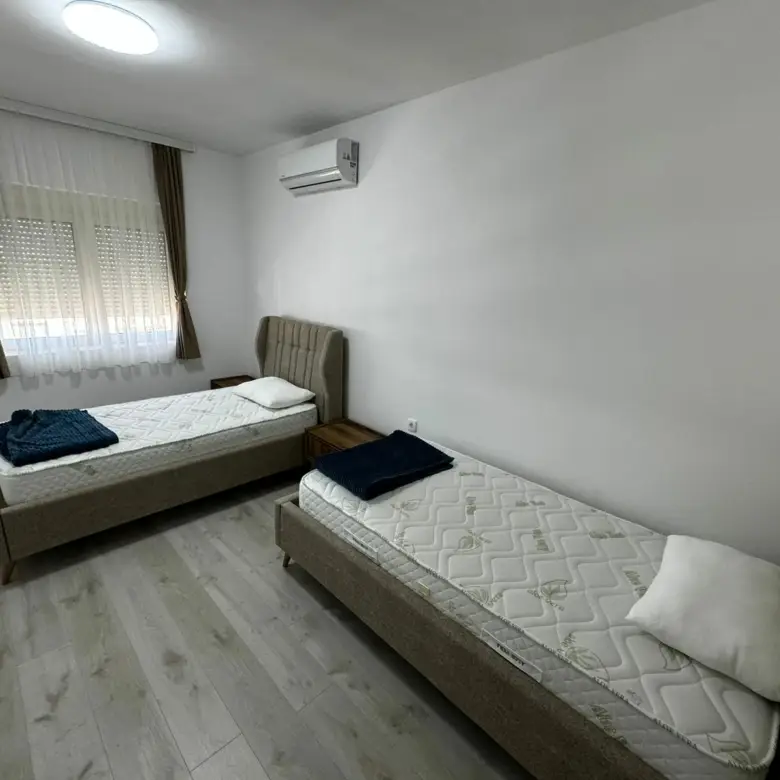 Modern Ulcinj bedroom with twin beds, wood floors, AC&mdash;ideal Montenegro real estate. Listed on immorenta.me by Ekosphere DOO.