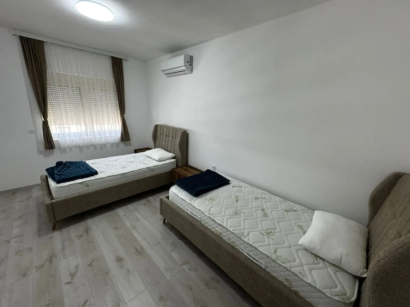 Modern Ulcinj bedroom with twin beds, wood floors, AC&mdash;ideal Montenegro real estate. Listed on immorenta.me by Ekosphere DOO.