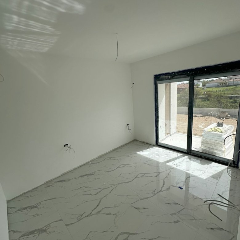 Bright, spacious room with marble tile floors and sliding glass doors&mdash;prime Ulcinj real estate by Ekosphere doo on immorenta.me.