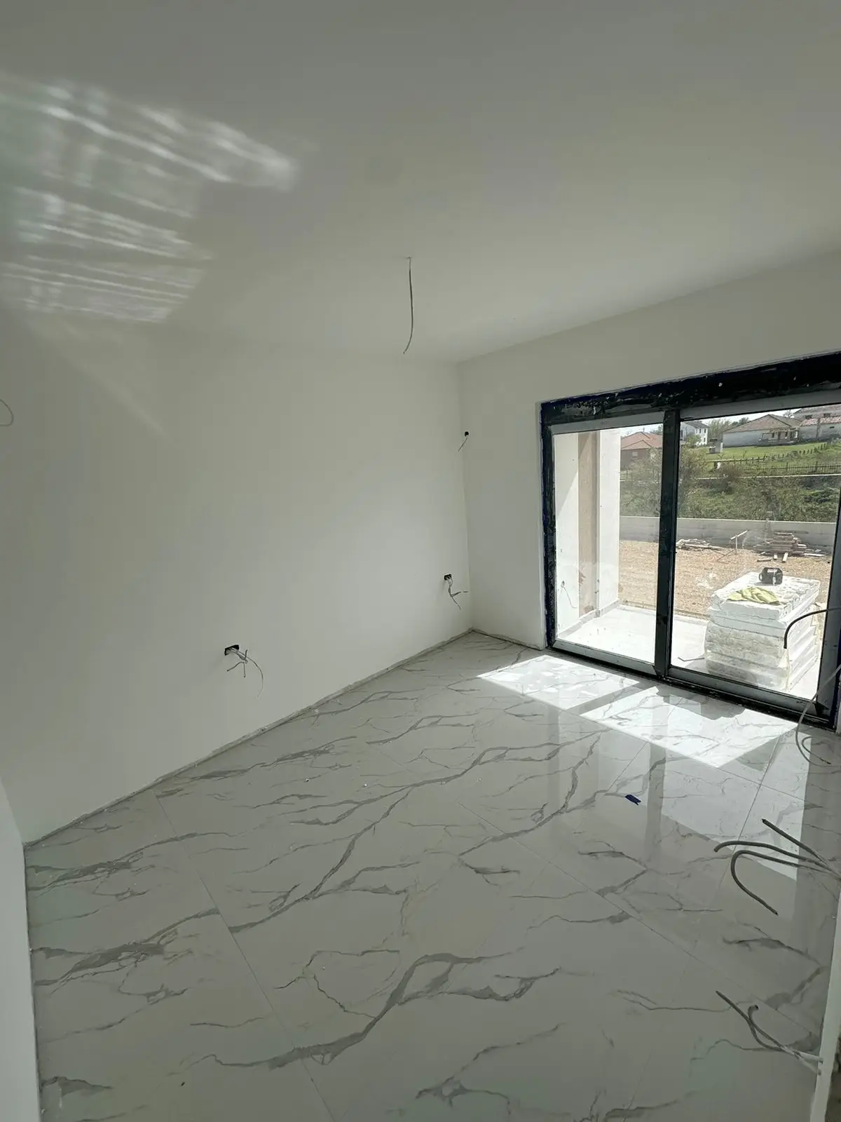 Bright, spacious room with marble tile floors and sliding glass doors&mdash;prime Ulcinj real estate by Ekosphere doo on immorenta.me.