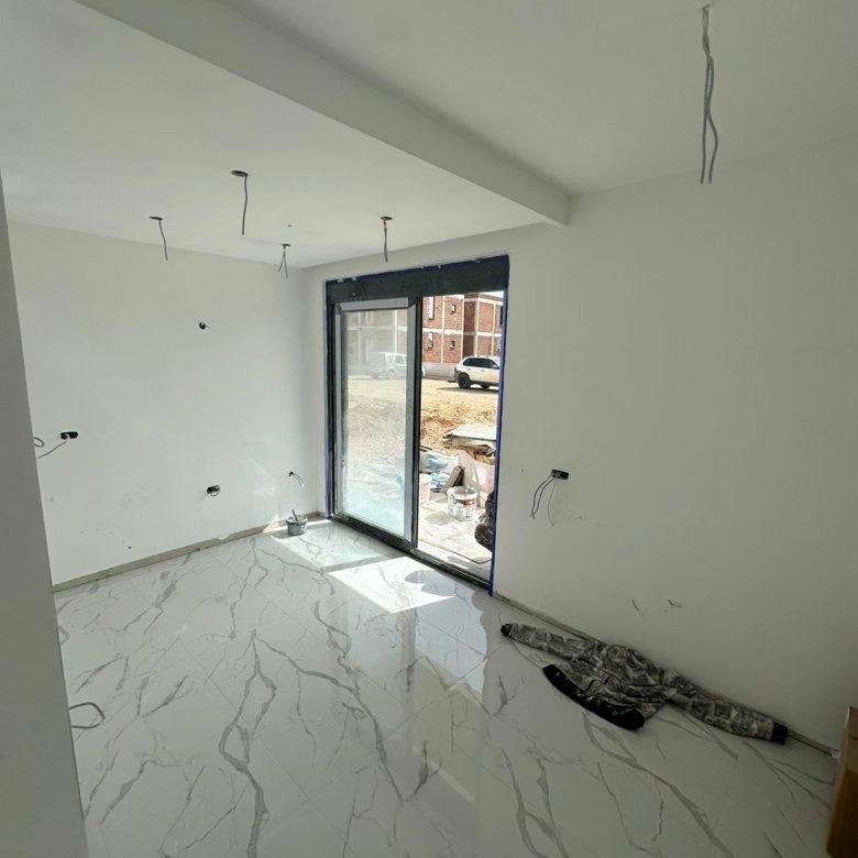 Spacious Ulcinj property: bright room with marble tile, large glass doors, ideal for investment. Listed on immorenta.me by Ekosphere.