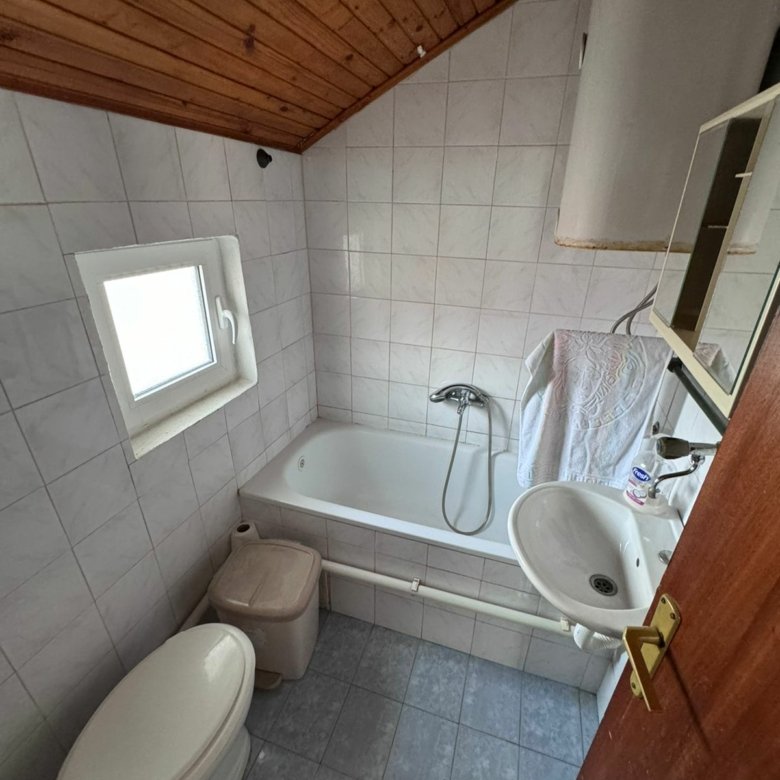 Modern bathroom in Ulcinj with bathtub, shower, tiled walls & wood ceiling&mdash;invest in Montenegro real estate via ekosphere&rsquo;s listings.