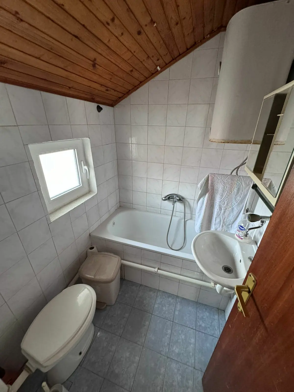 Modern bathroom in Ulcinj with bathtub, shower, tiled walls & wood ceiling&mdash;invest in Montenegro real estate via ekosphere&rsquo;s listings.