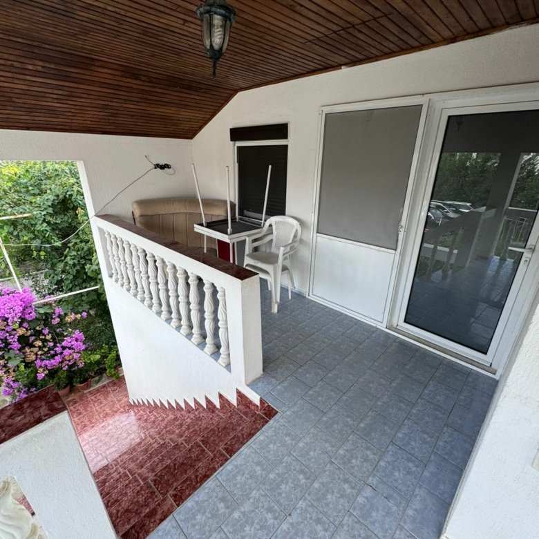 Spacious covered balcony with tiled flooring, white railings, and garden decor&mdash;perfect Ulcinj investment via immorenta.me by ekosphere doo.