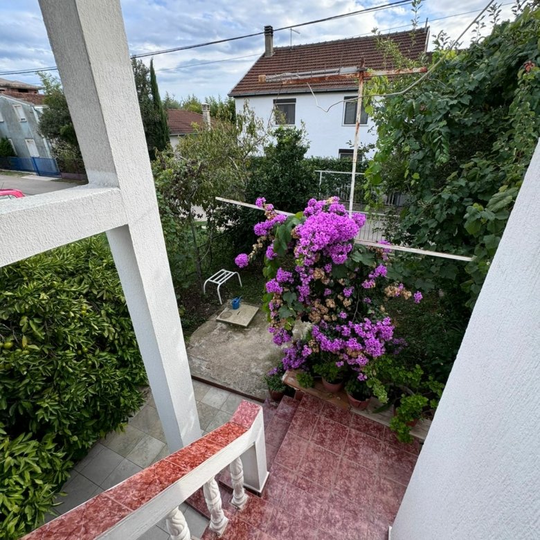 Stunning Ulcinj property: red-tiled stairs, lush courtyard, elegant white home&mdash;ideal Montenegro investment, by ekosphere doo.