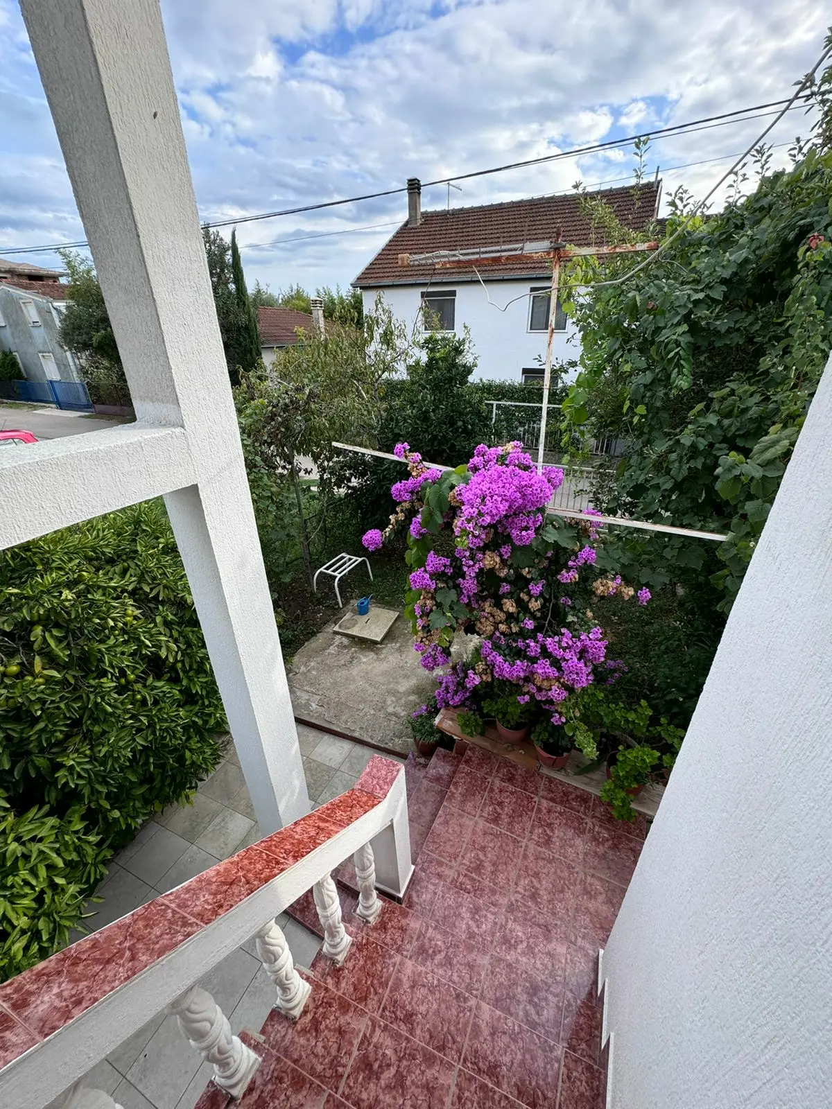 Stunning Ulcinj property: red-tiled stairs, lush courtyard, elegant white home&mdash;ideal Montenegro investment, by ekosphere doo.