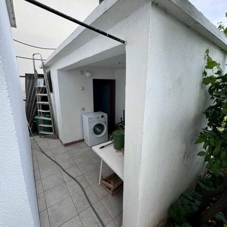 Covered outdoor area in Ulcinj with tiled floor, white walls, washing machine&mdash;an ideal investment property by Ekosphere on immorenta.me.