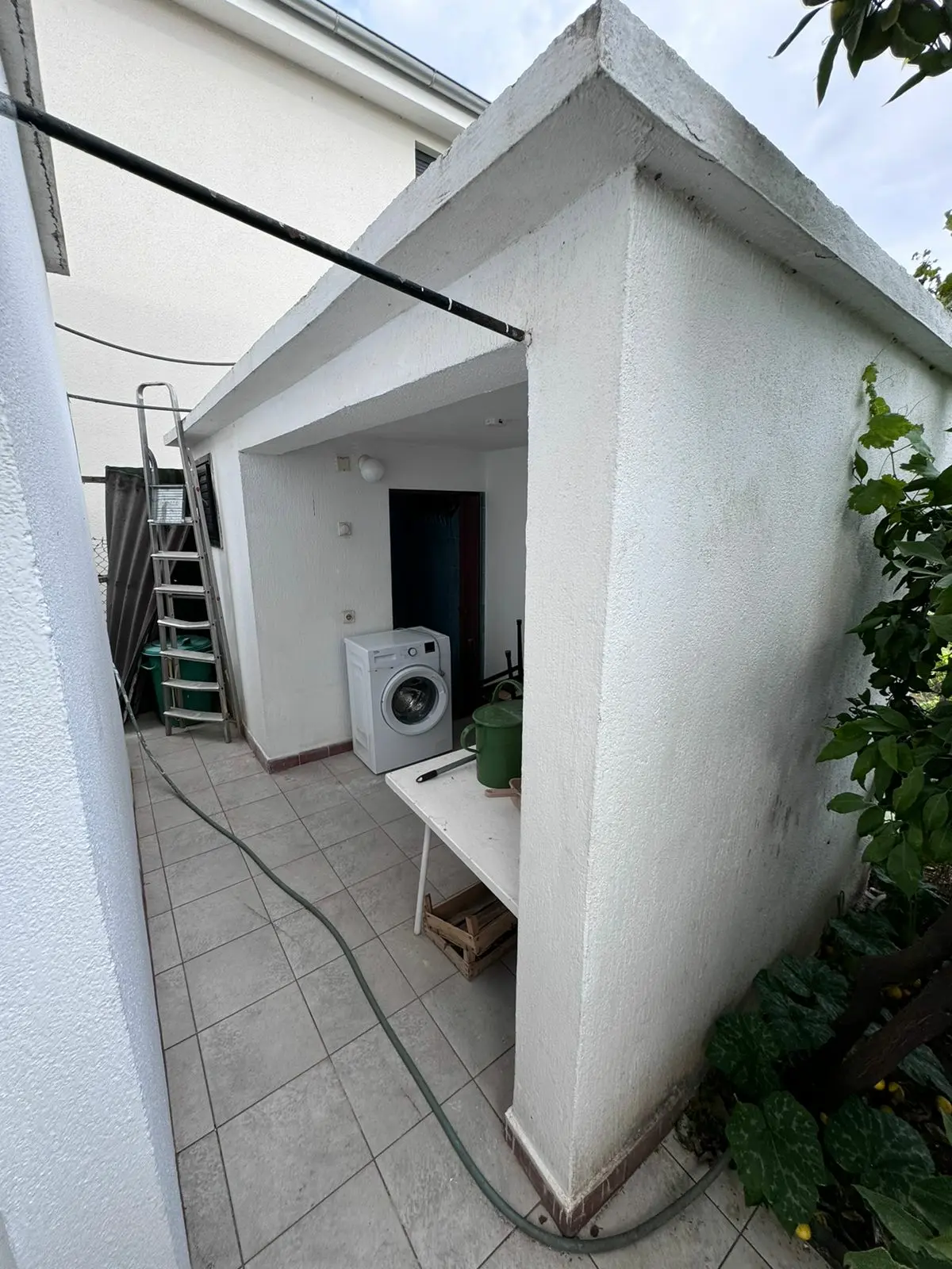 Covered outdoor area in Ulcinj with tiled floor, white walls, washing machine&mdash;an ideal investment property by Ekosphere on immorenta.me.