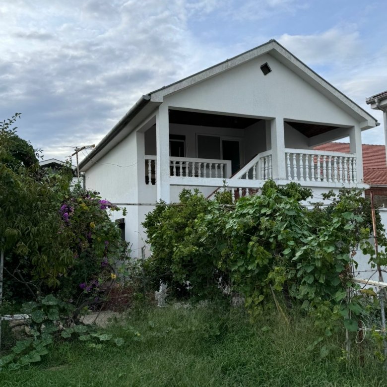 Modern white house with porch, lush garden, and balcony&mdash;prime Ulcinj real estate. Invest with immorenta.me by ekosphere doo.