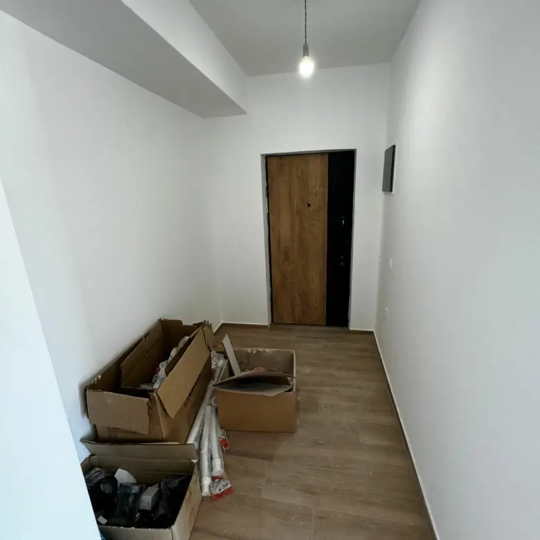 Modern hallway with white walls, wood floors, overhead lighting&mdash;prime investment in Ulcinj. Exclusive at immorenta.me by ekosphere doo.