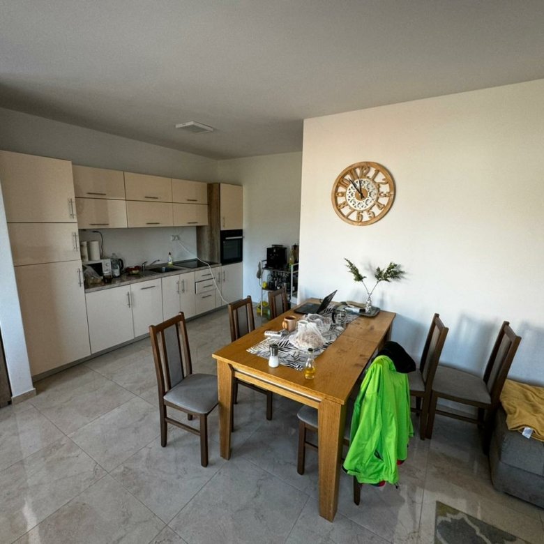 Modern Ulcinj kitchen with spacious dining area, white cabinets, and wood table&mdash;exclusive real estate on immorenta.me by ekosphere doo.