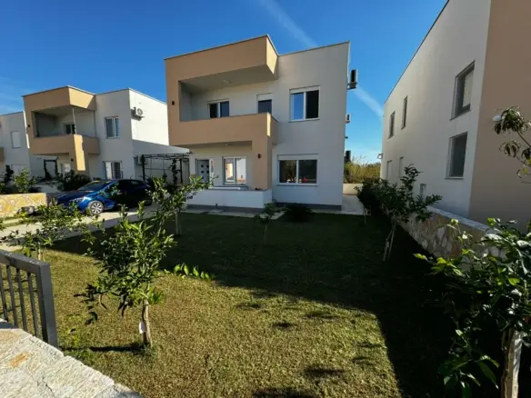 Stylish modern two-story home in Ulcinj, Montenegro with large windows, balcony & manicured lawn&mdash;listed by immorenta.me.