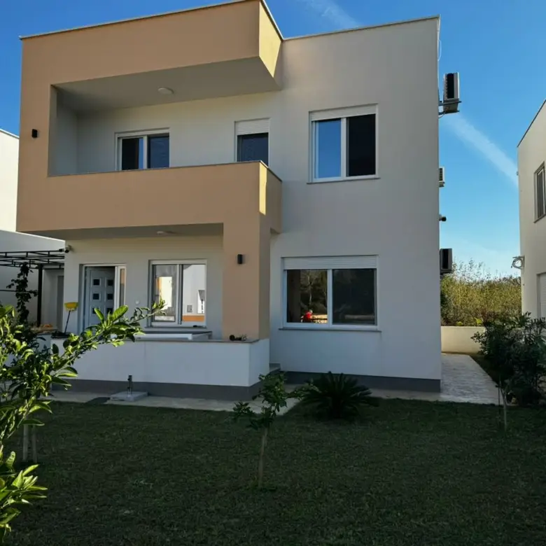 Modern 2-story house in Ulcinj, Montenegro: beige & white facade, balcony, lush lawn&mdash;exclusive on immorenta.me by ekosphere doo.