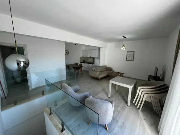Stylish Ulcinj home: light wood floors, gray armchairs, beige sofa, glass stairway&mdash;exclusive at immorenta.me by ekosphere doo.