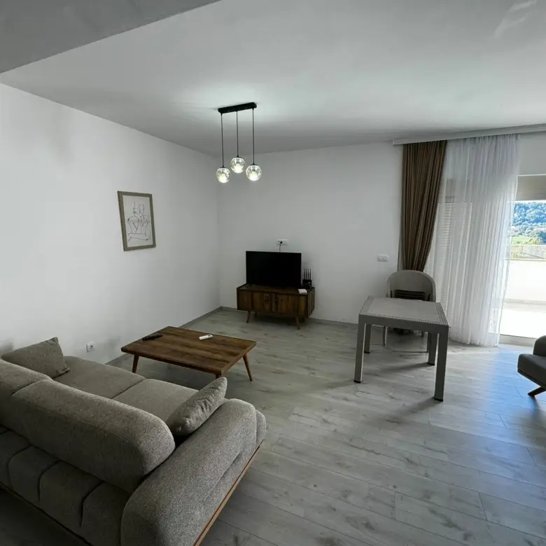 Modern Ulcinj apartment: stylish gray living room, bright windows, premium finishes. Invest with immorenta.me by Ekosphere doo.