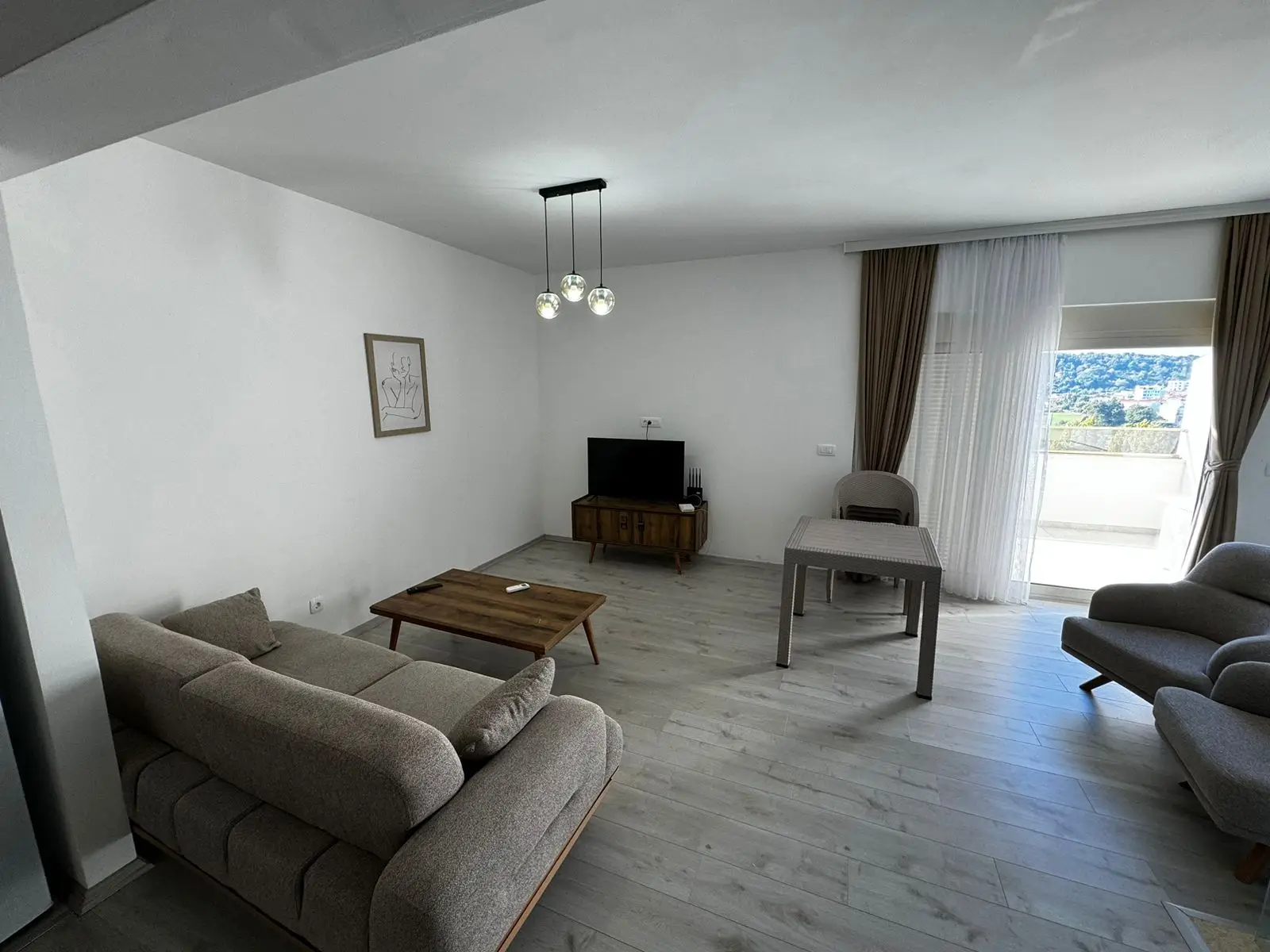 Modern Ulcinj apartment: stylish gray living room, bright windows, premium finishes. Invest with immorenta.me by Ekosphere doo.