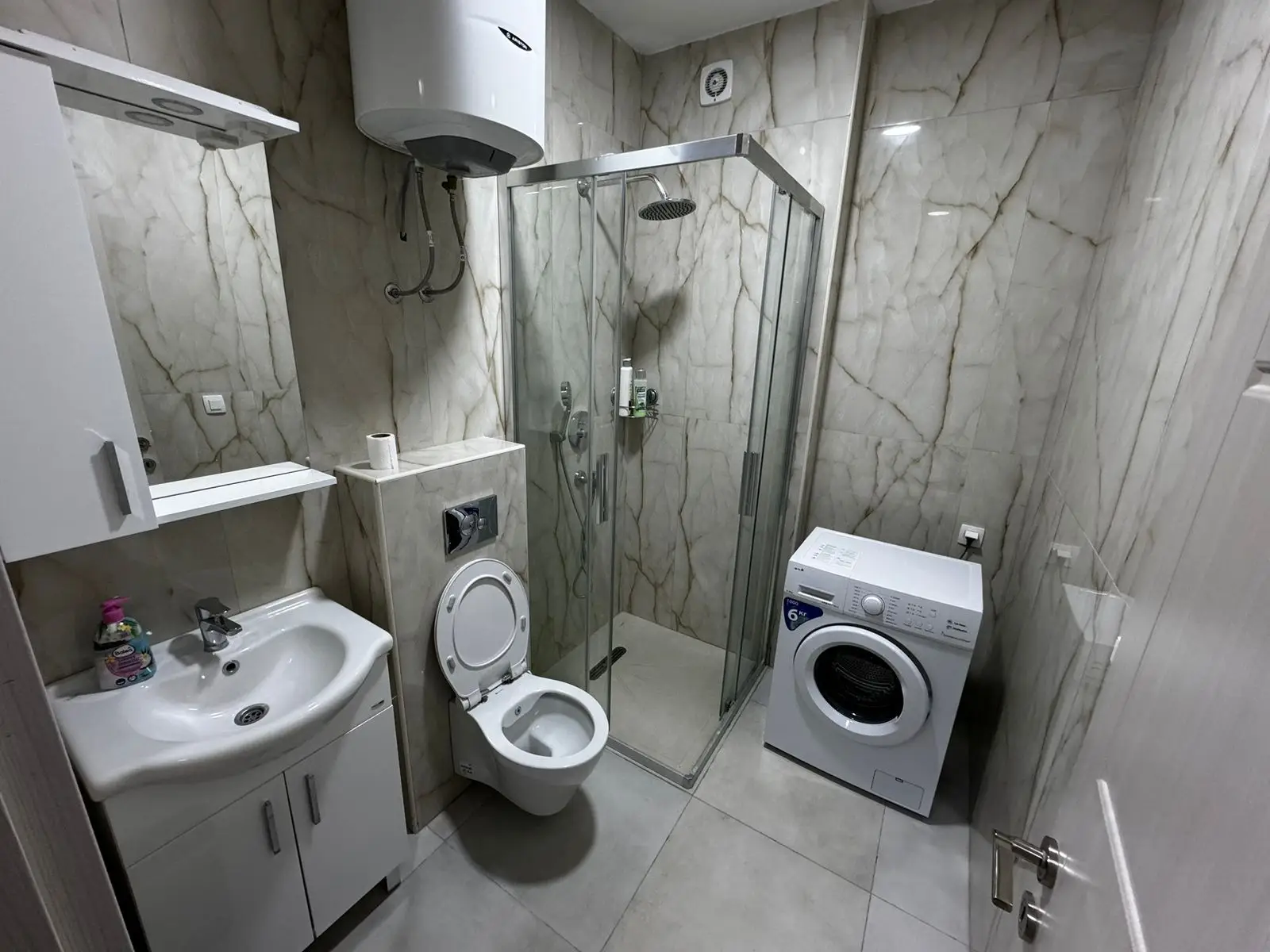 Elegant Ulcinj property bathroom: marble walls, modern fixtures, washer, premium ekosphere heater. Montenegro-listings.me exclusivity.