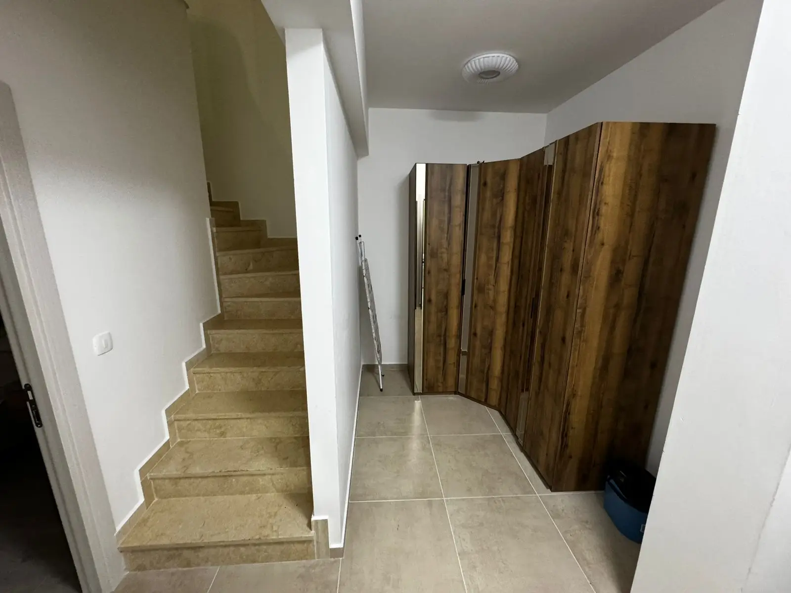 Modern hallway in Ulcinj property: beige tiles, sleek stairs, bright walls&mdash;exclusive at immorenta.me by ekosphere doo.