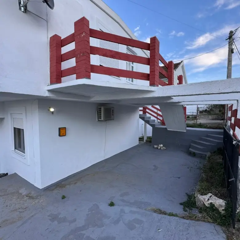 Modern white two-story property in Ulcinj, Montenegro, with red railings, exterior stairs & parking&mdash;ideal investment via immorenta.me by ekosphere doo.