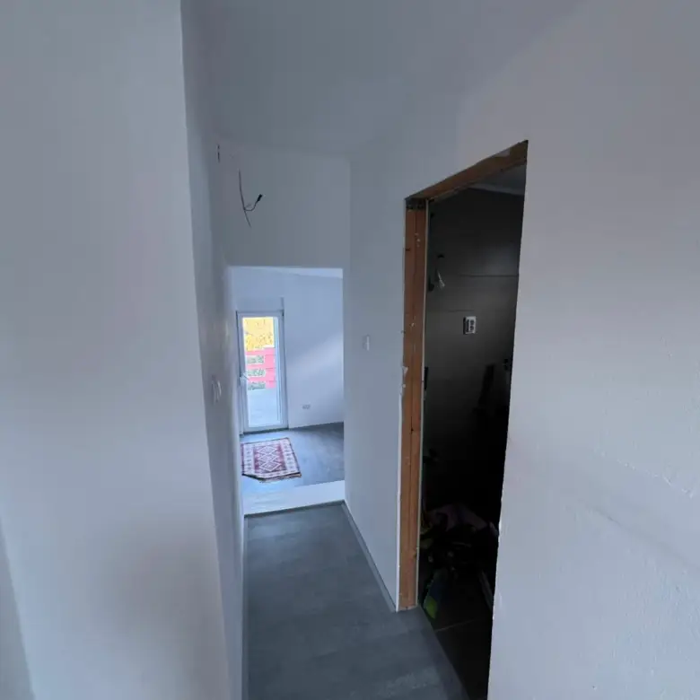 Bright hallway with sleek gray floors leads to a sunny modern room&mdash;superior Ulcinj property investment by Ekosphere, immorenta.me.