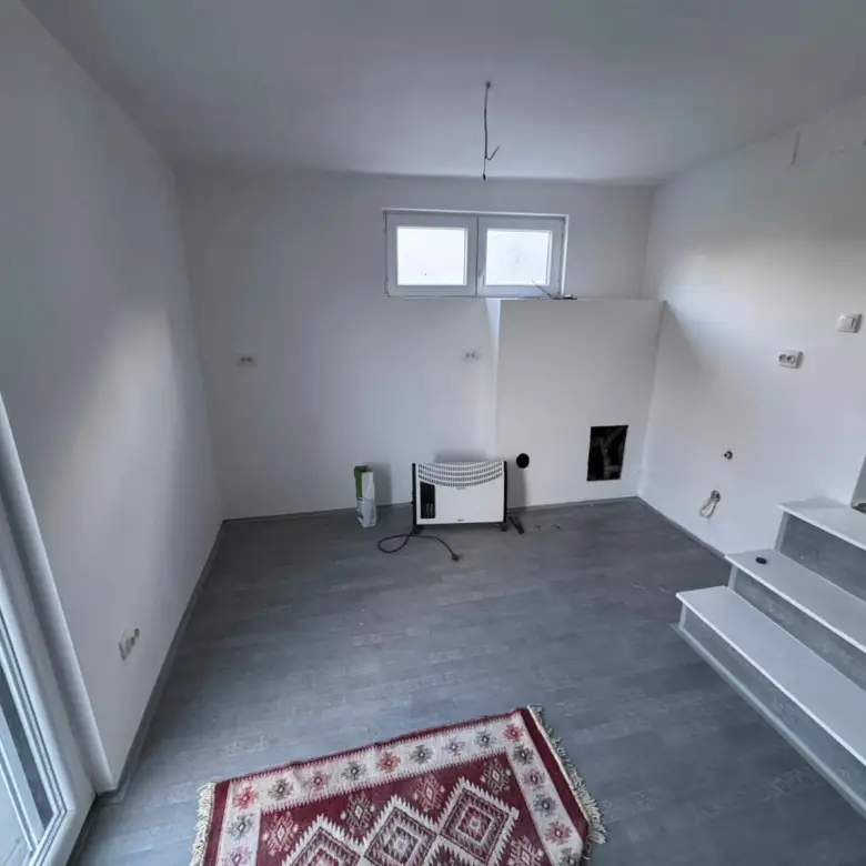 Modern unfurnished room in Ulcinj with gray floors, white walls, windows, and steps&mdash;investment property from Ekosphere doo on immorenta.me.