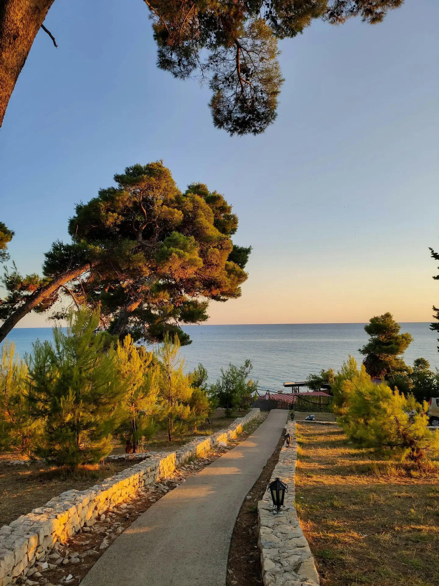 Der Sonnenuntergang beleuchtet einen malerischen Weg zur Adria und pr&auml;sentiert erstklassige Immobilien in Ulcinj von immorenta.me &ndash; von Ekosphere DOO.