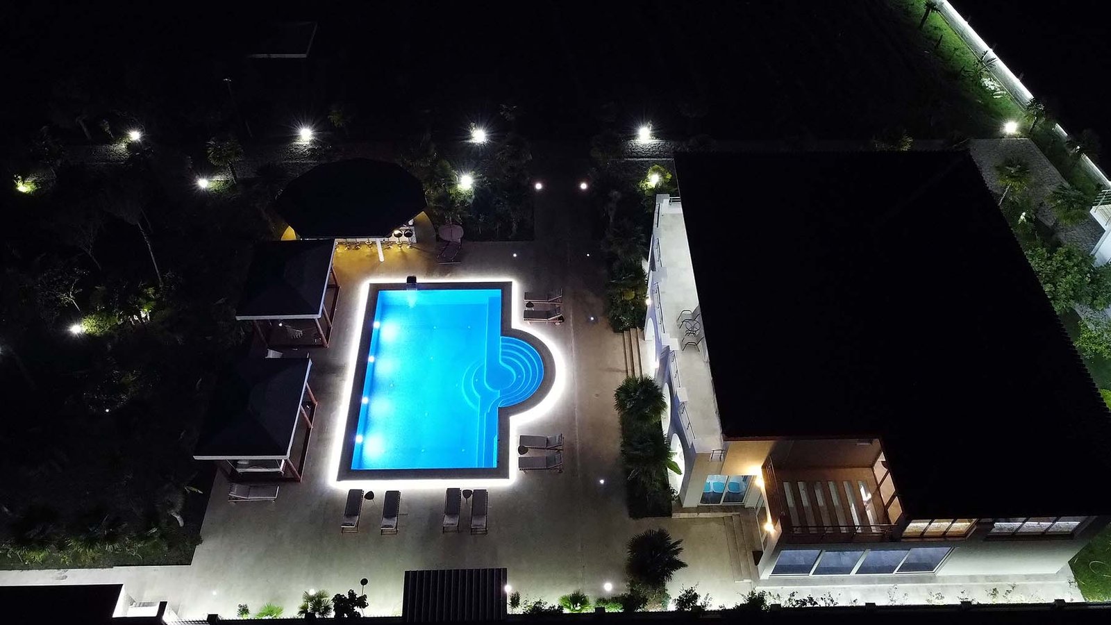 Luxurious illuminated pool with cabanas and lounge area at premium Ulcinj property&mdash;exclusive on immorenta.me by Ekosphere doo.