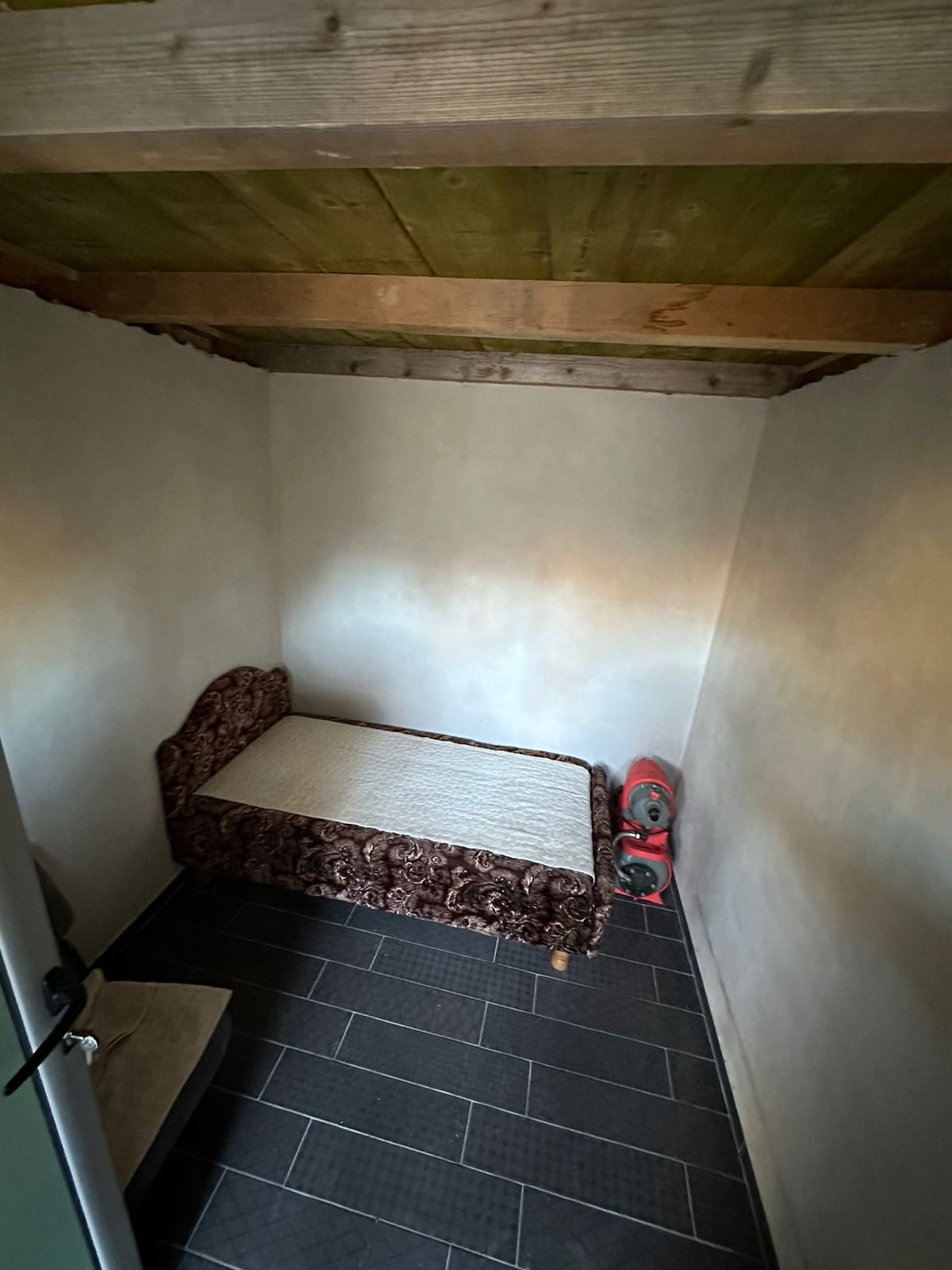 Charming Ulcinj property: sleek black-tiled floor, wooden ceiling, cozy bed&mdash;great Montenegro investment via immorenta.me.