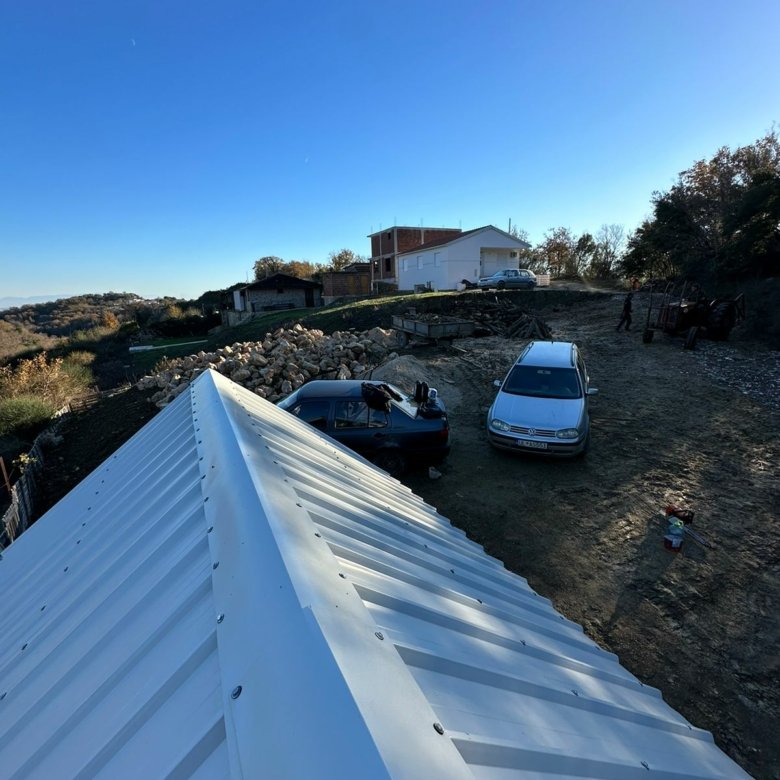 Prime Ulcinj property view: investment-ready land, parking, and nearby development under a clear sky. By Ekosphere/ immorenta.me.