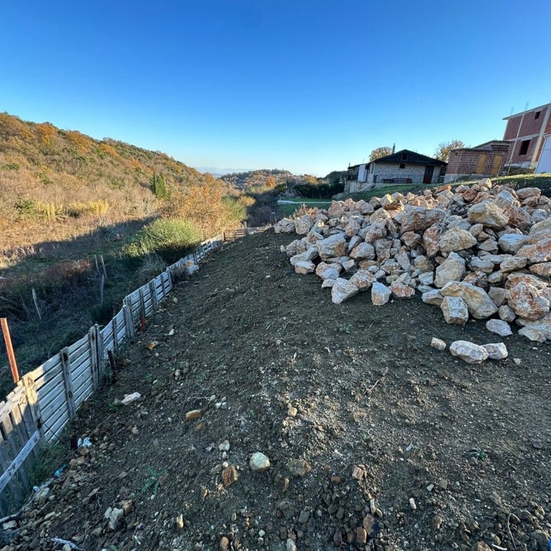 Prime Ulcinj land with development potential&mdash;clear lot, rock pile, fenced, scenic hills/homes. Montenegro-listings.me by ekosphere doo.