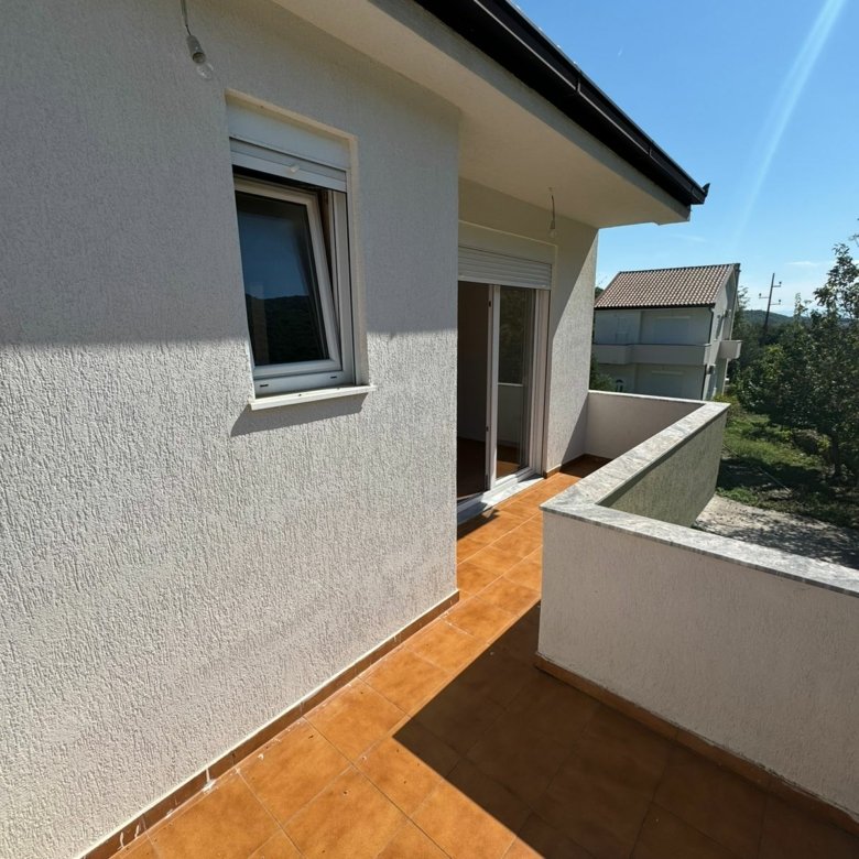 Bright balcony in Ulcinj, Montenegro with tiled floors, glass doors, and scenic views&mdash;top real estate by Ekosphere on immorenta.me.