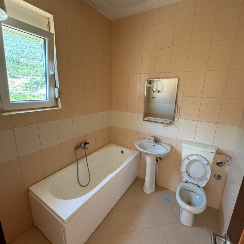 Charming Ulcinj bathroom with tan tiles, bright window, modern fixtures&mdash;ideal property investment on immorenta.me by ekosphere doo.