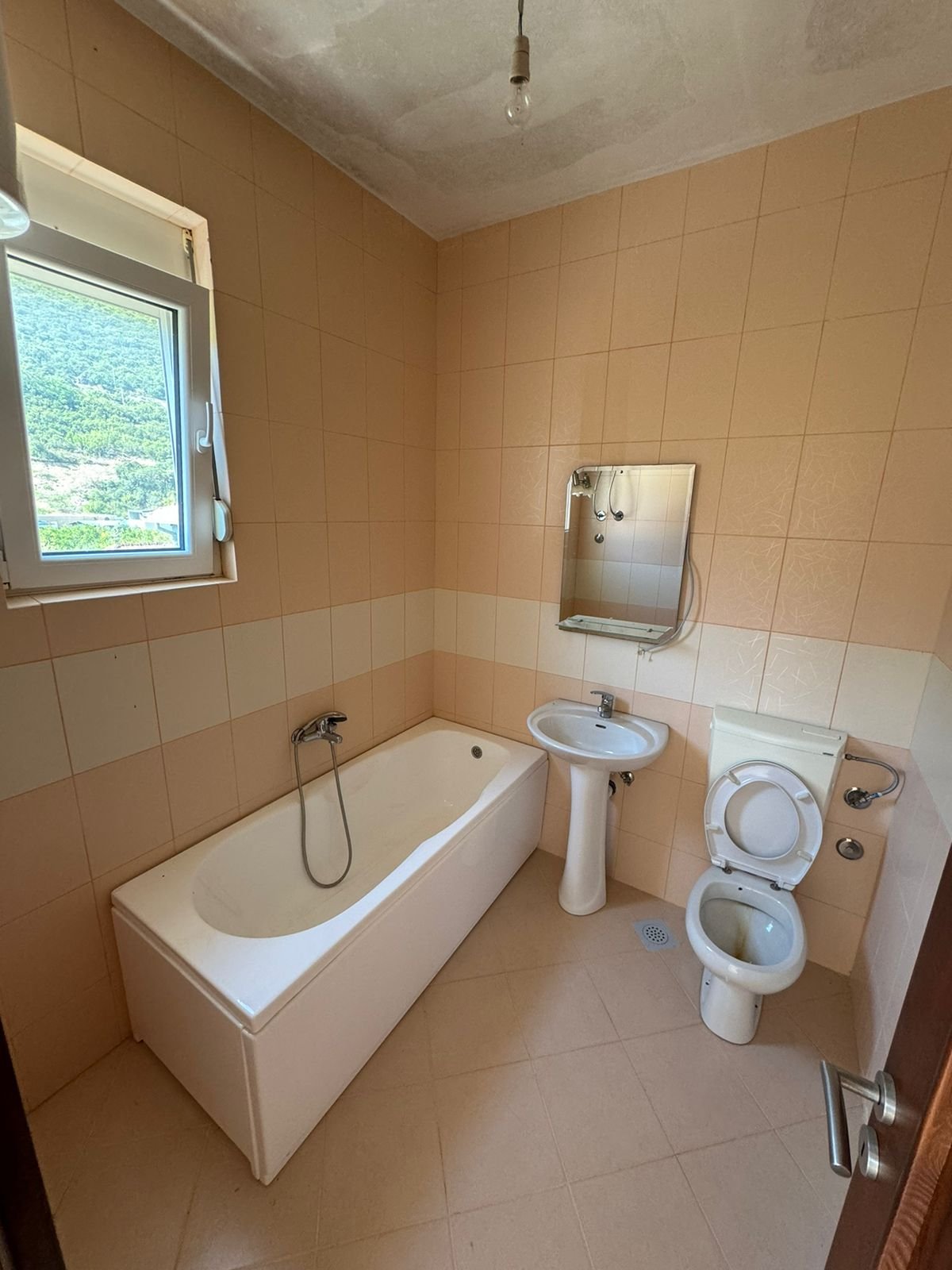 Charming Ulcinj bathroom with tan tiles, bright window, modern fixtures&mdash;ideal property investment on immorenta.me by ekosphere doo.