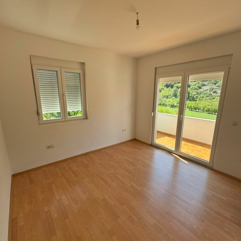 Invest in Ulcinj: bright room with wood floors, white walls, balcony & green views. Listed by immorenta.me (ekosphere doo).