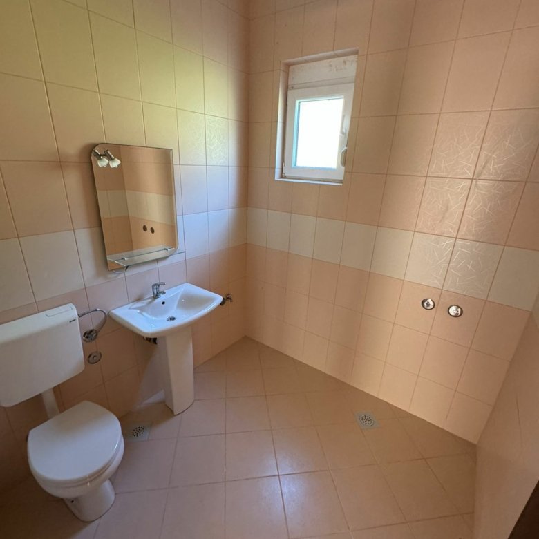 Modern bathroom in Ulcinj with beige tiles, window, quality fittings&mdash;prime Montenegro real estate by immorenta.me (Ekosphere DOO).