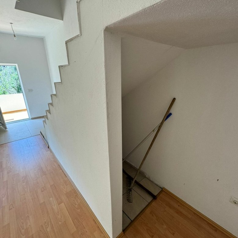 Modern staircase with storage, light wood floors, and pristine white interiors&mdash;prime Ulcinj property at immorenta.me by Ekosphere.
