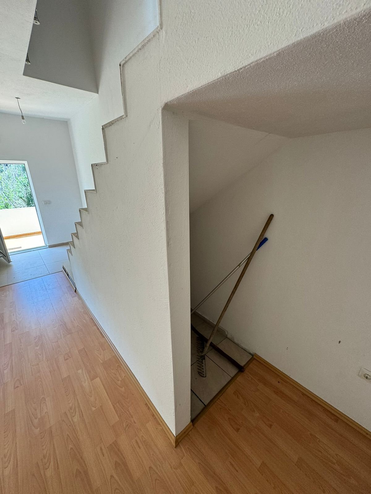 Modern staircase with storage, light wood floors, and pristine white interiors&mdash;prime Ulcinj property at immorenta.me by Ekosphere.