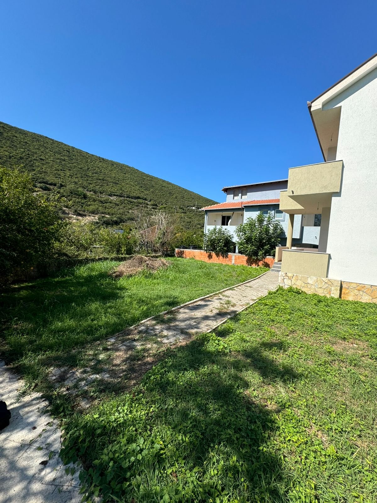 Modern white villa with balconies, lush yard, and mountain views in Ulcinj&mdash;prime Montenegro real estate from Ekosphere at immorenta.me.