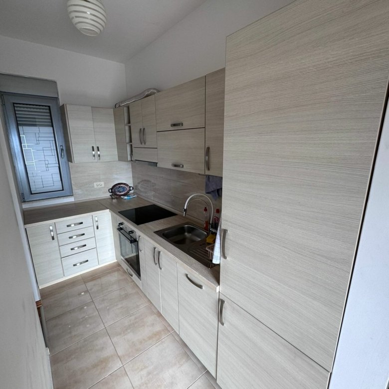Modern narrow kitchen in Ulcinj with light wood cabinets, built-in oven, tiled floor&mdash;ideal investment on immorenta.me by ekosphere doo.