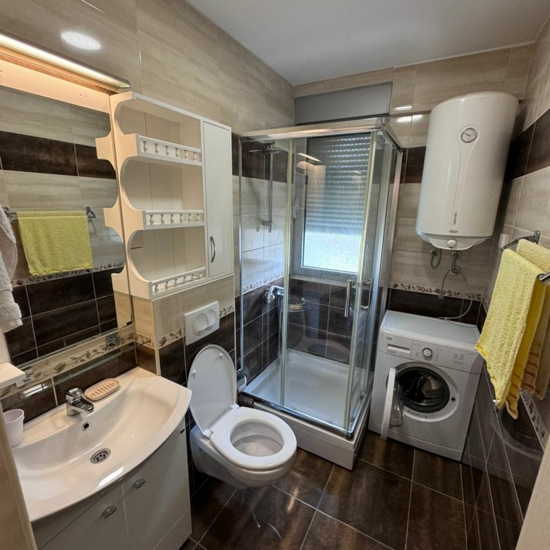 Stylish Ulcinj bathroom: elegant tiles, quality fixtures, washing machine; a smart Montenegro investment via immorenta.me.