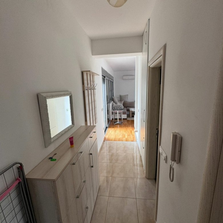 Modern Ulcinj apartment: tiled hallway, wood-floored living room, sleek lighting, built-ins&mdash;ekosphere doo & immorenta.me.