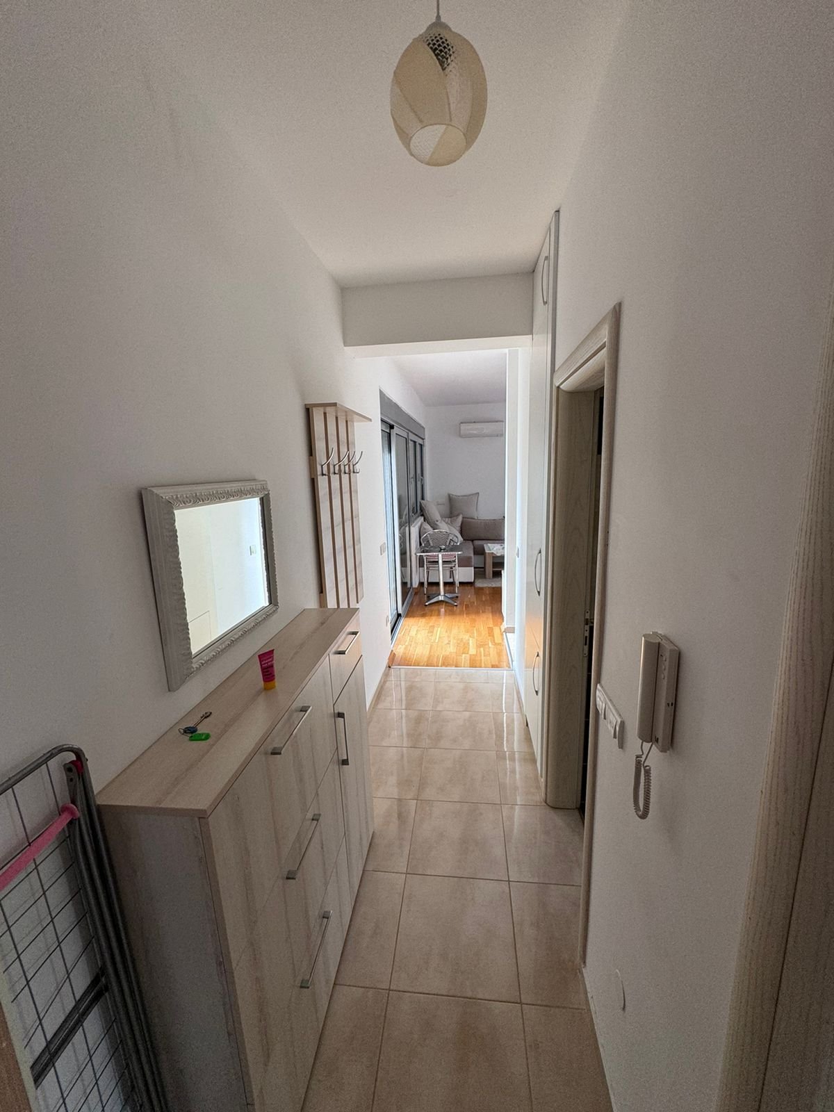 Modern Ulcinj apartment: tiled hallway, wood-floored living room, sleek lighting, built-ins&mdash;ekosphere doo & immorenta.me.