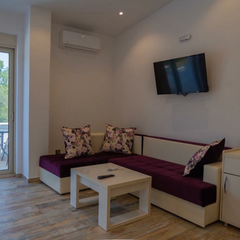 Experience luxury living in Ulcinj Montenegro&mdash;modern lounge, elegant maroon sofa, patio access. Exclusive via immorenta.me by ekosphere doo.