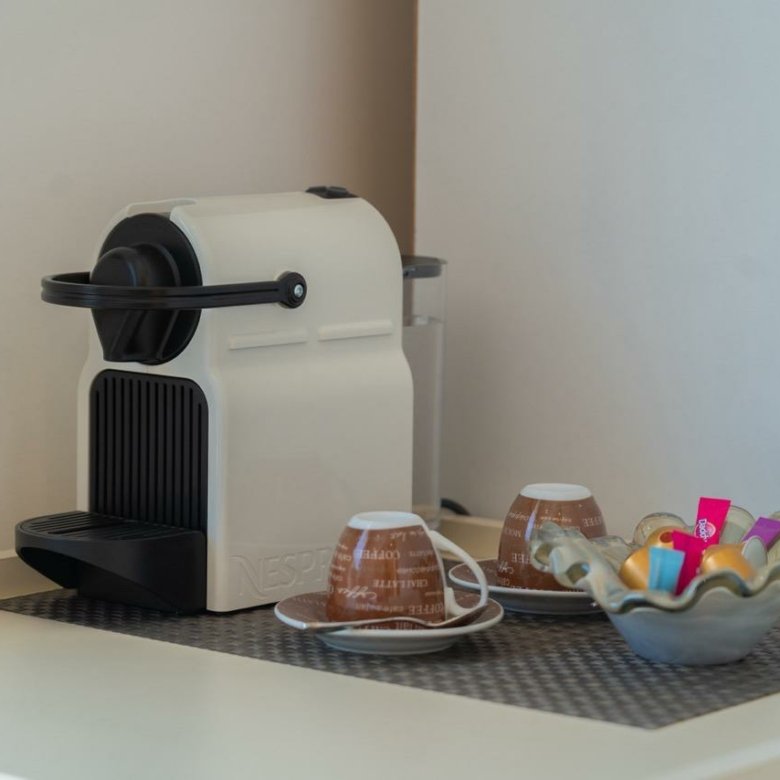 Modern white espresso machine and coffee setup creates a welcoming touch in Ulcinj properties&mdash;find your dream home with Ekosphere doo.