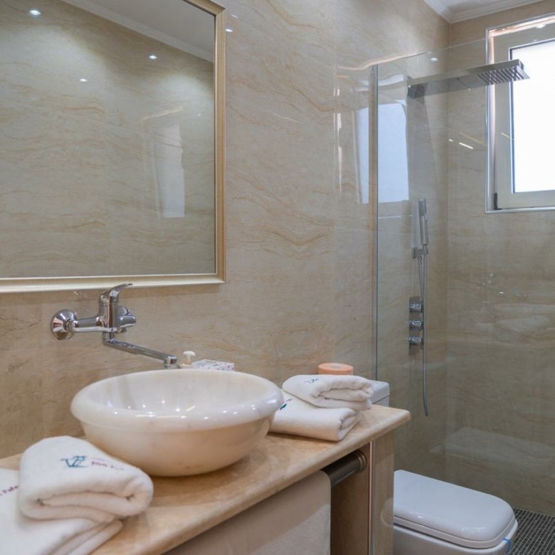 Elegant modern bathroom with beige marble, premium fixtures, in top Ulcinj real estate. Invest via immorenta.me by ekosphere doo.